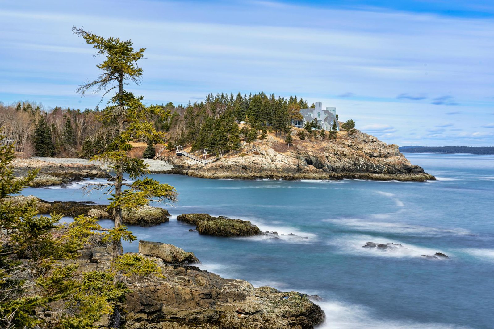 sea and a rocky coastline with trees on the shore