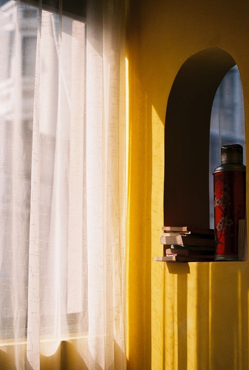 cozy yellow nook with sunlit books and flask
