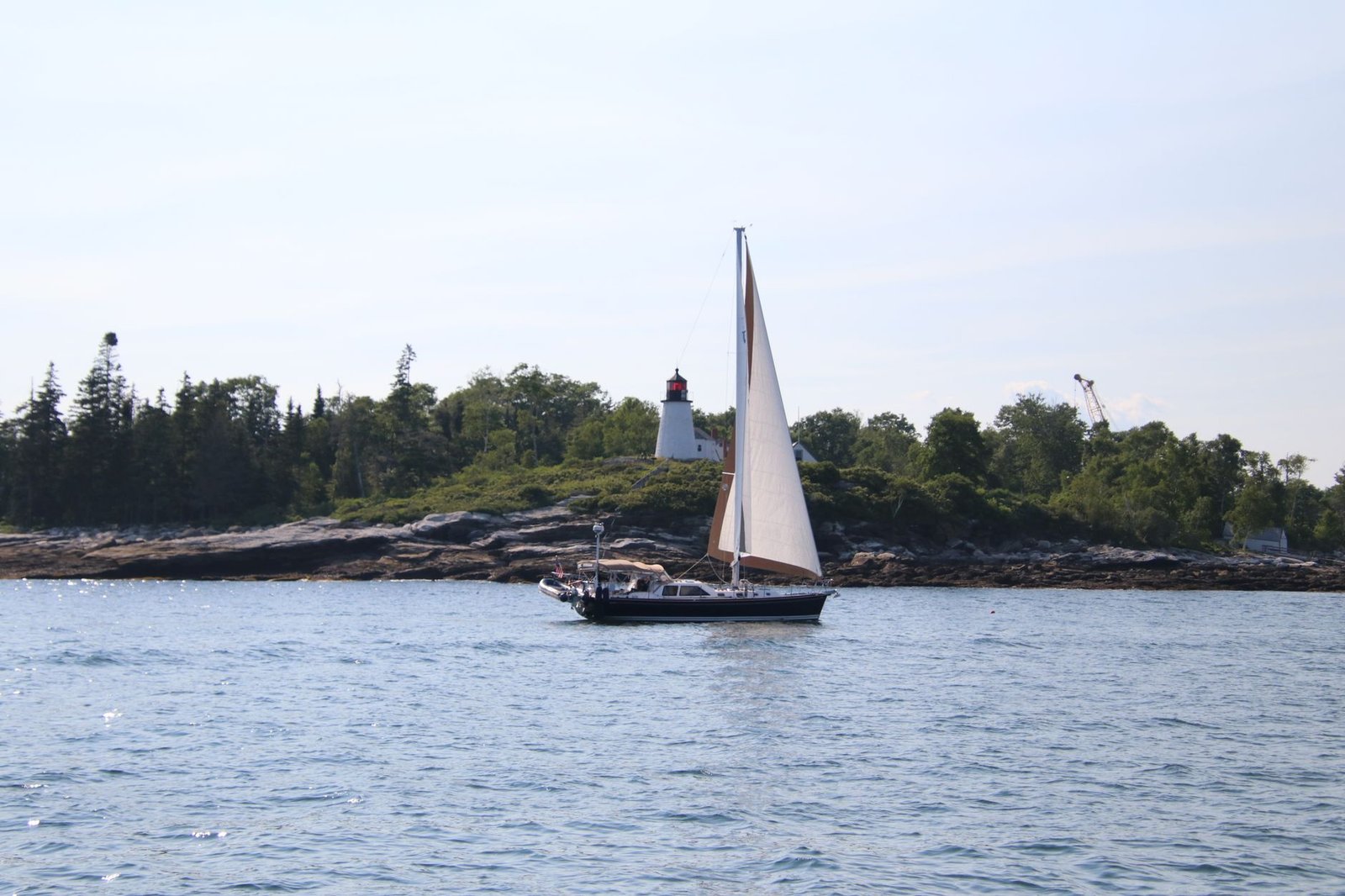 sailboat in front of picturesque lighthouse landscape